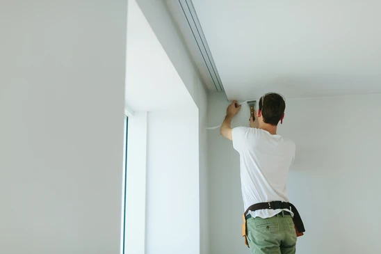 B&acirc;timent masculin faisant des travaux de finition au plafond dans des appartements, r&eacute;novant la maison