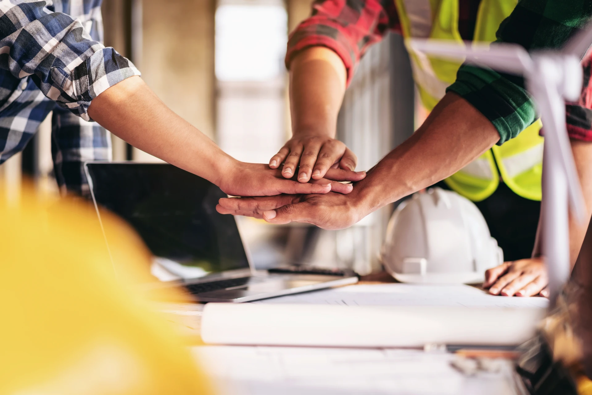 Deux hommes en tenue professionnelle analysent des plans d'architecture sur une table blanche dans un bureau moderne