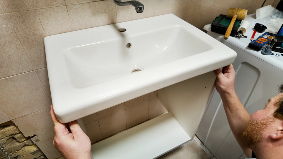 Un plombier professionnel intervient sous un évier de cuisine moderne