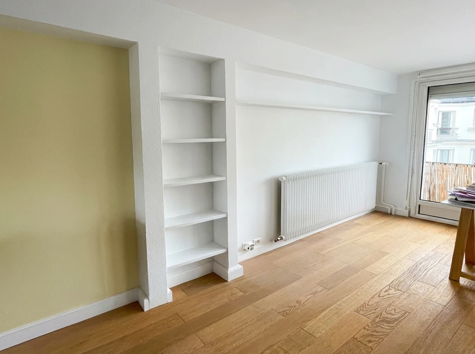 Scène d'intérieur de rénovation avec escabeau métallique et seau blanc contenant outils de peinture