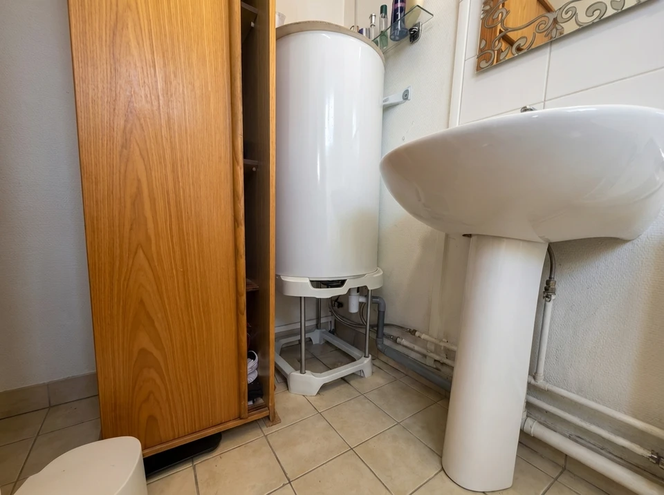 Salle de bain mansardée en cours de rénovation avec carrelage métro blanc partiellement posé, radiateur sèche-serviettes, sanitaires WC et bidet installés